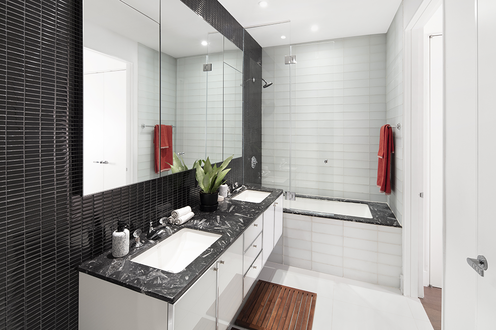 a black and white bathroom with two sinks and a tub
