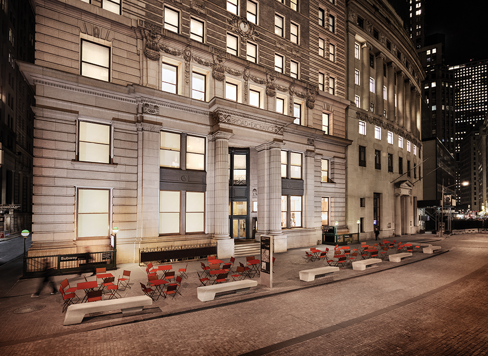 an outdoor seating area of a building in the city at night