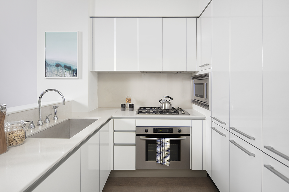 a kitchen with white cabinets and a sink and a stove