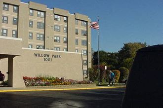 a man walking in front of a building with an american flag