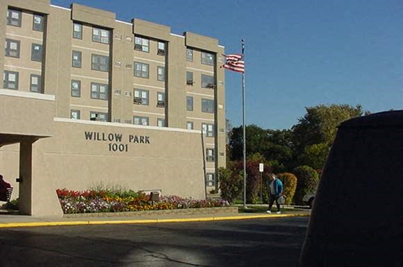 a man walking in front of the willow park 100 building