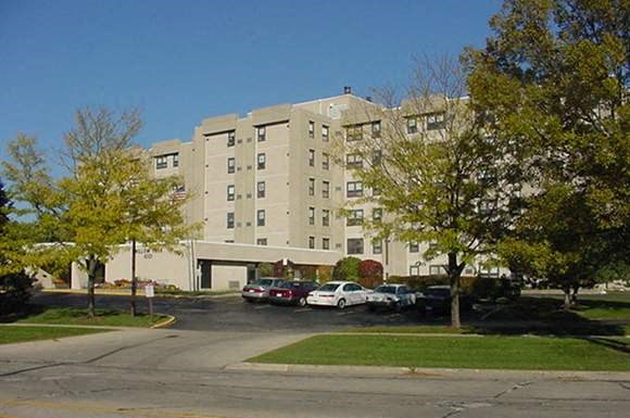 an apartment building with cars parked in a parking lot