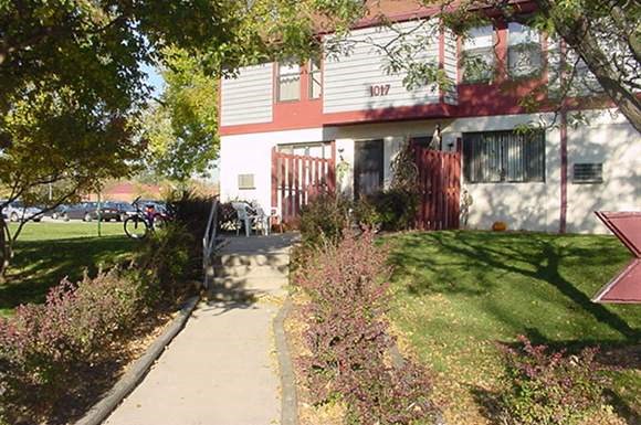 a red and white house with a sidewalk in front of it