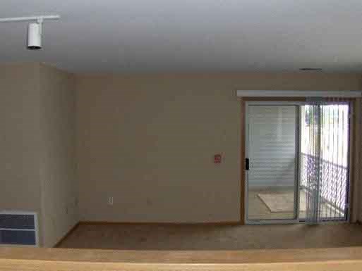 an empty living room with a door to a patio