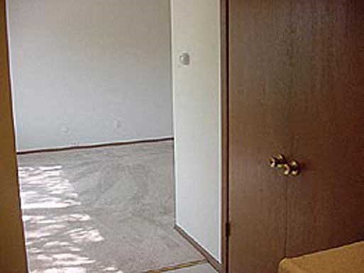 an open door to a living room with a white wall