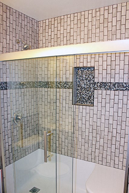 a tiled bathroom with a shower and a sink