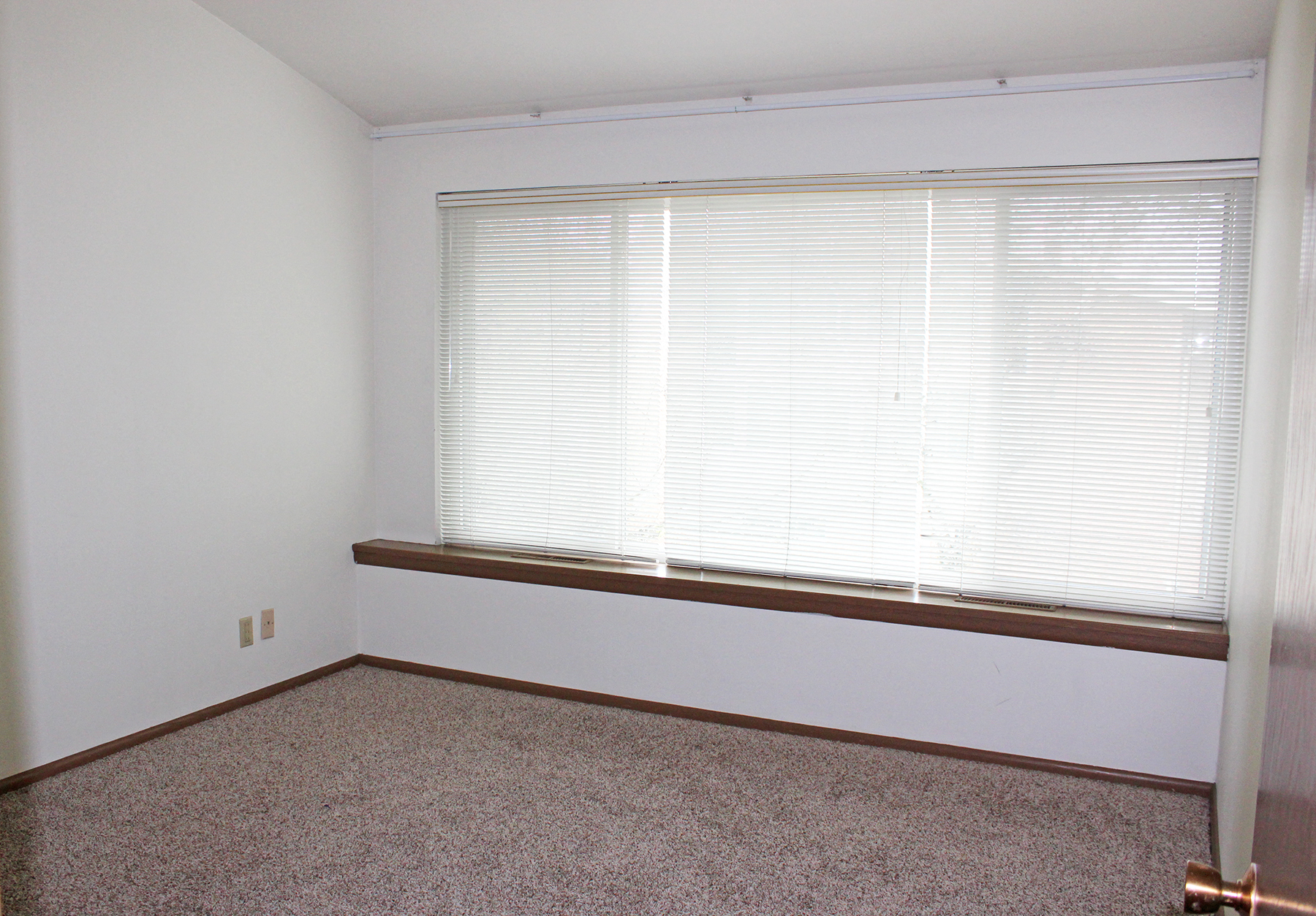 a room with a large window and a carpeted floor