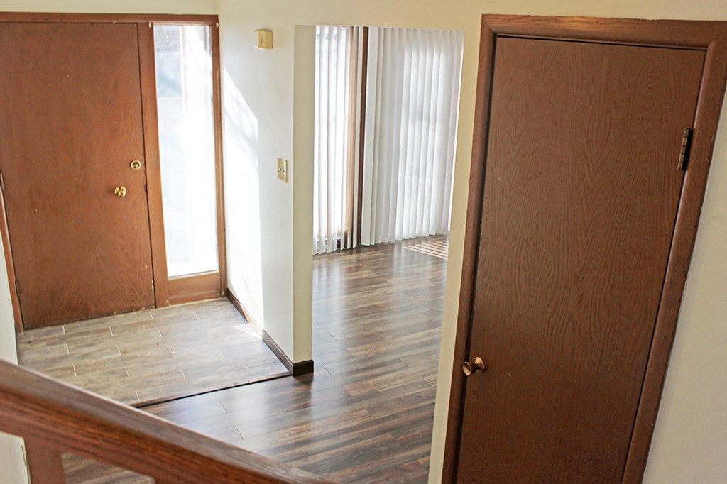 an empty room with wooden floors and a wooden door