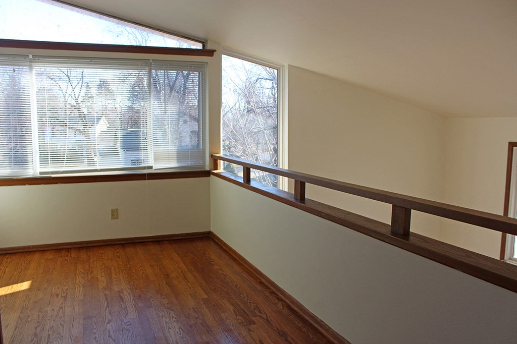 a living room with a large window and wooden floors