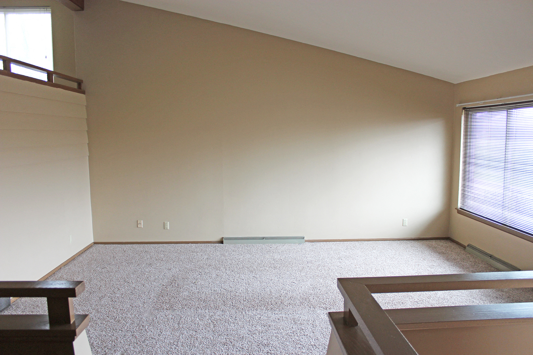 a living room with white walls and a large window