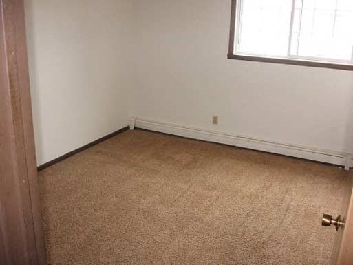 a room with a carpeted floor and a window