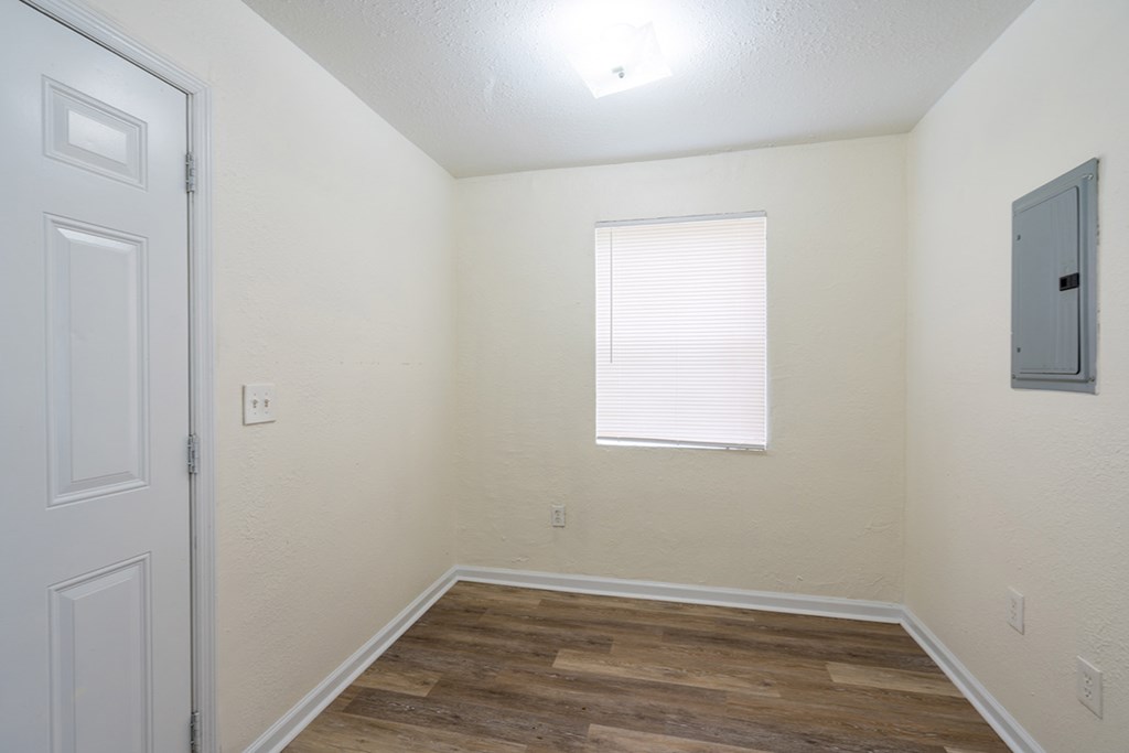 an empty room with a window and a door