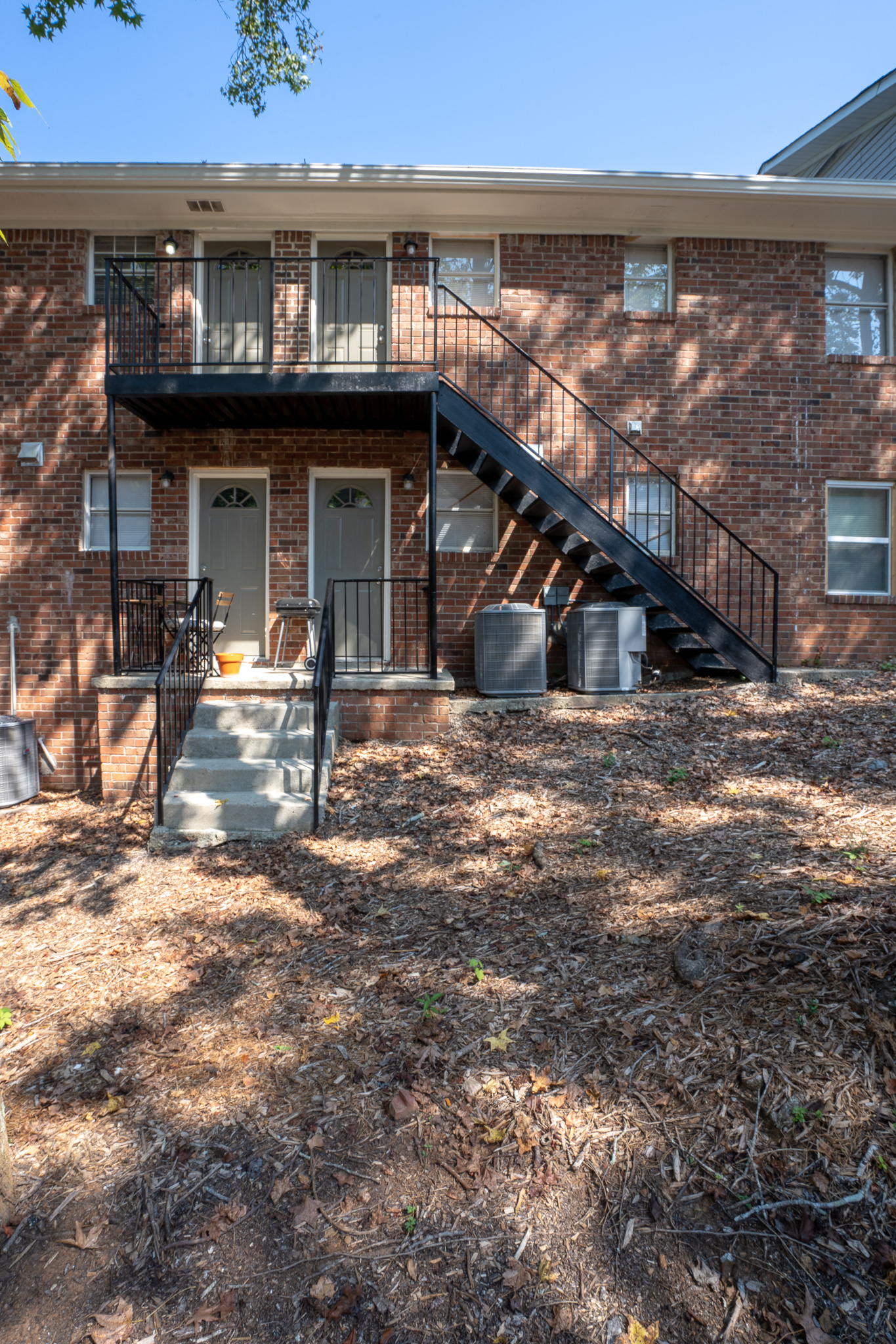 the front of a brick building with a black staircase