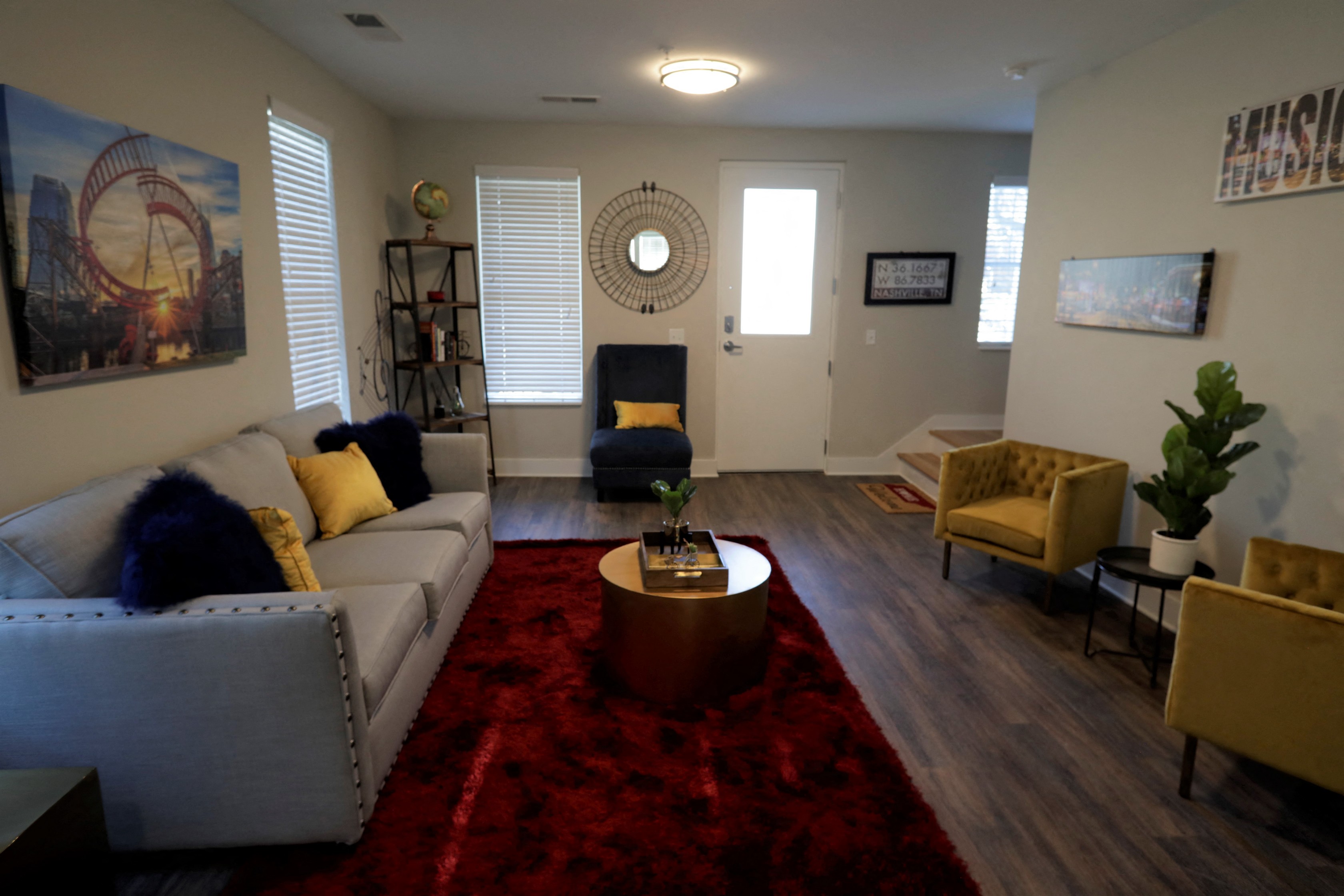an empty living room with a red rug and a white couch