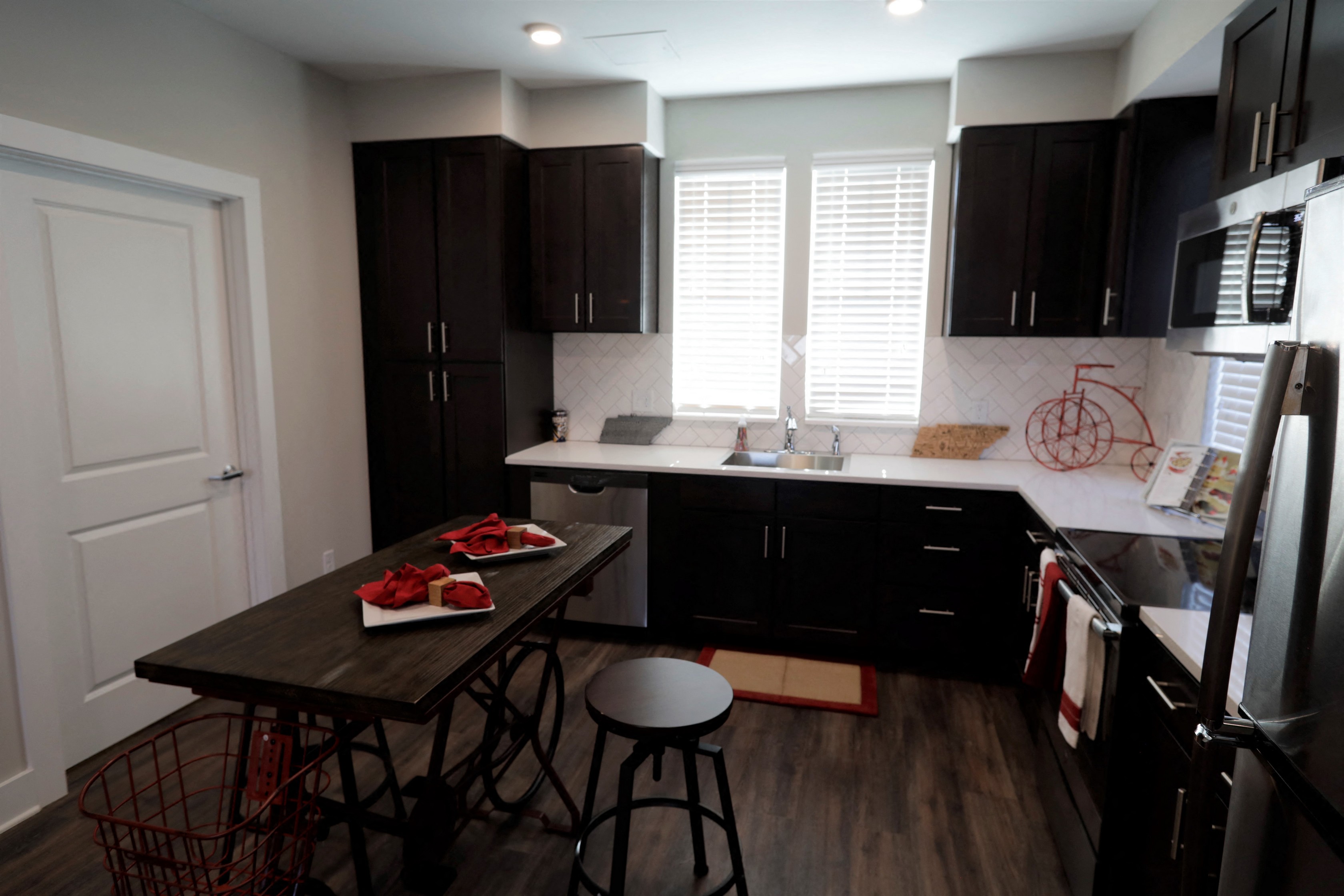 a kitchen with black cabinets and white counter tops and a wooden table