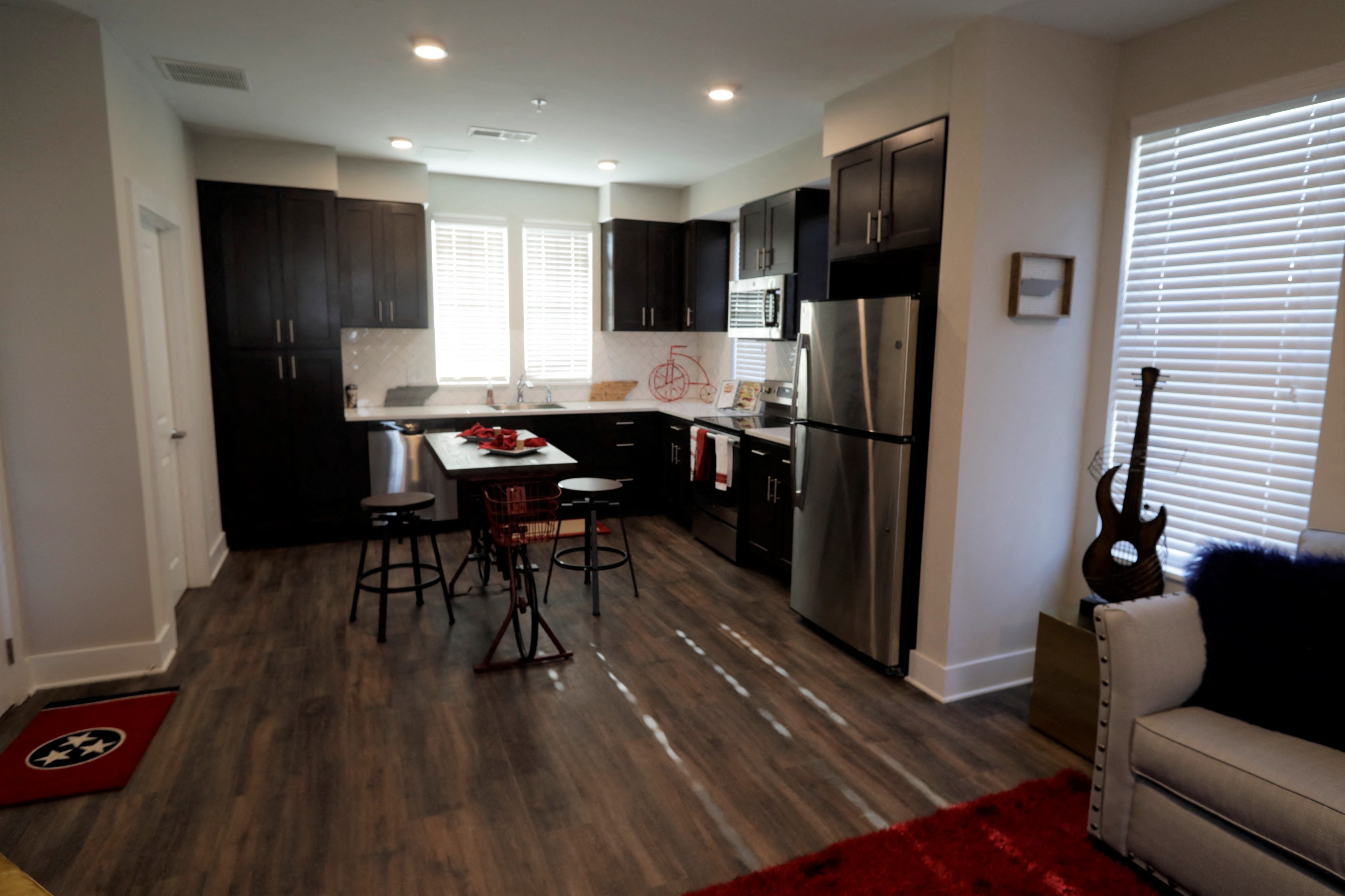 an open kitchen and living room with a guitar in the corner