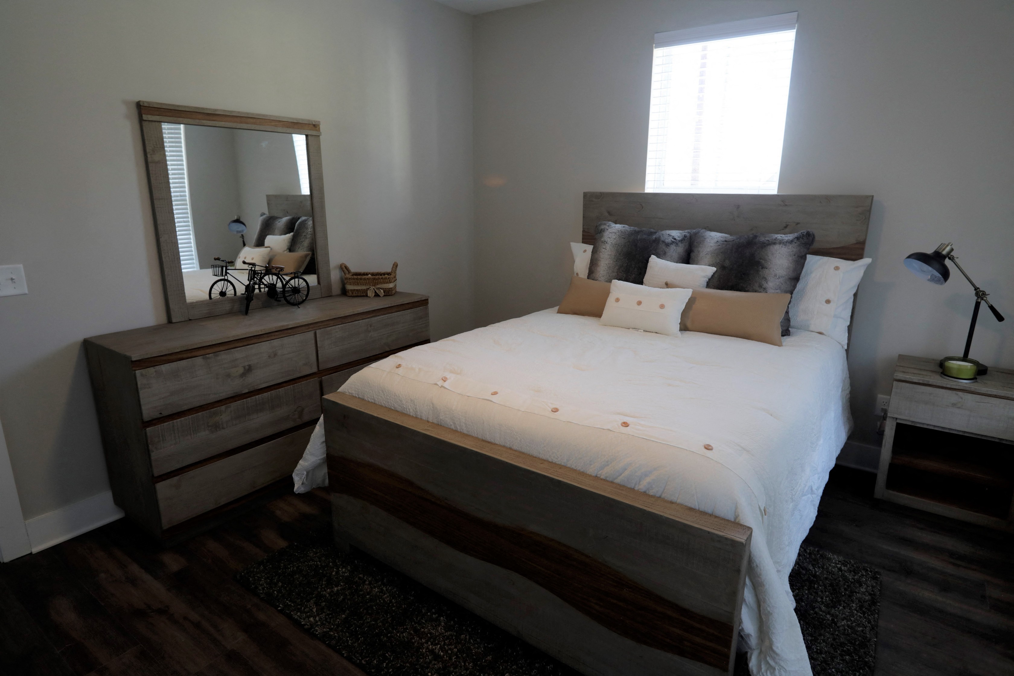 a bedroom with a bed and a dresser with a mirror