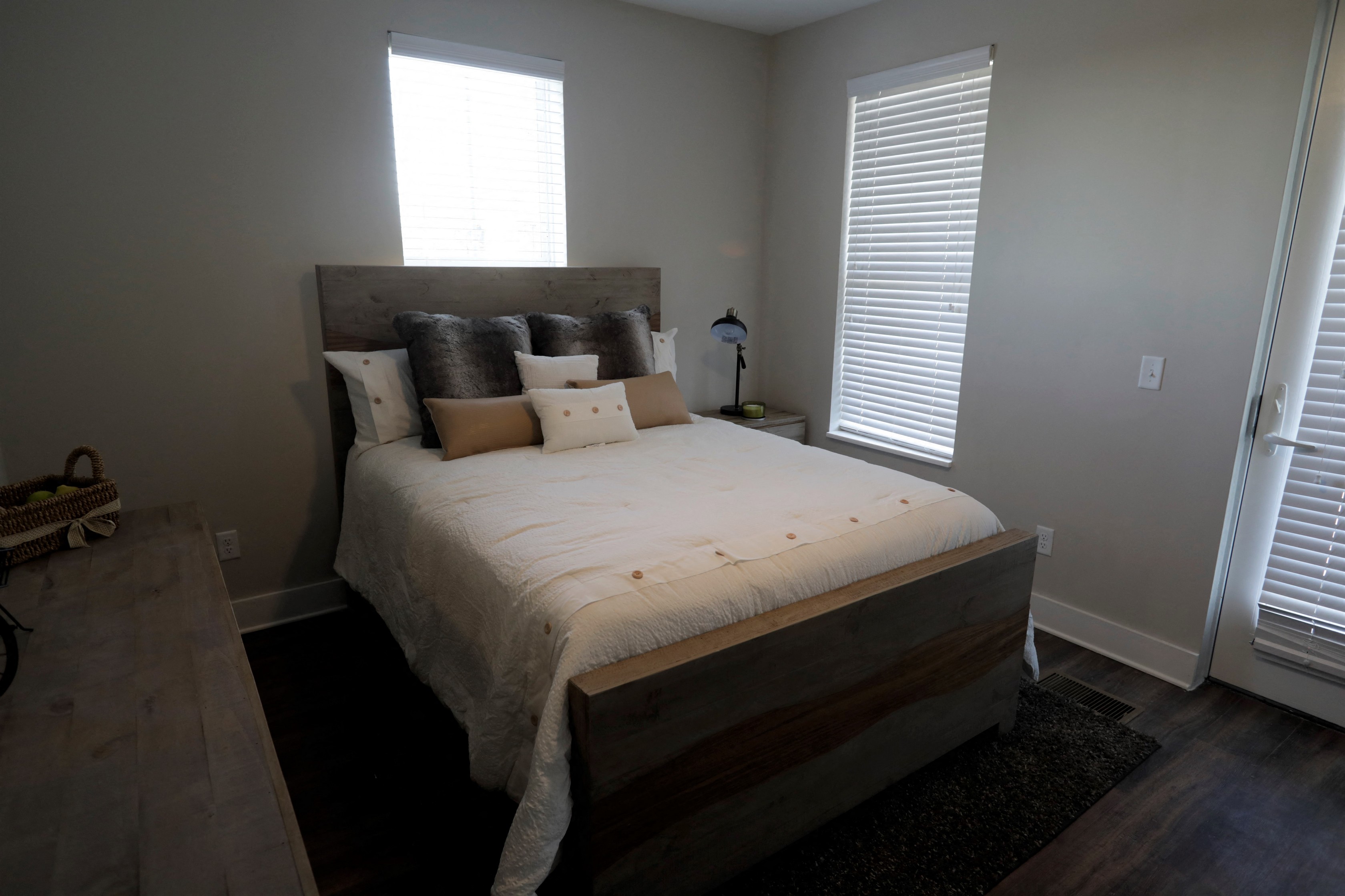 a bedroom with a bed and two windows