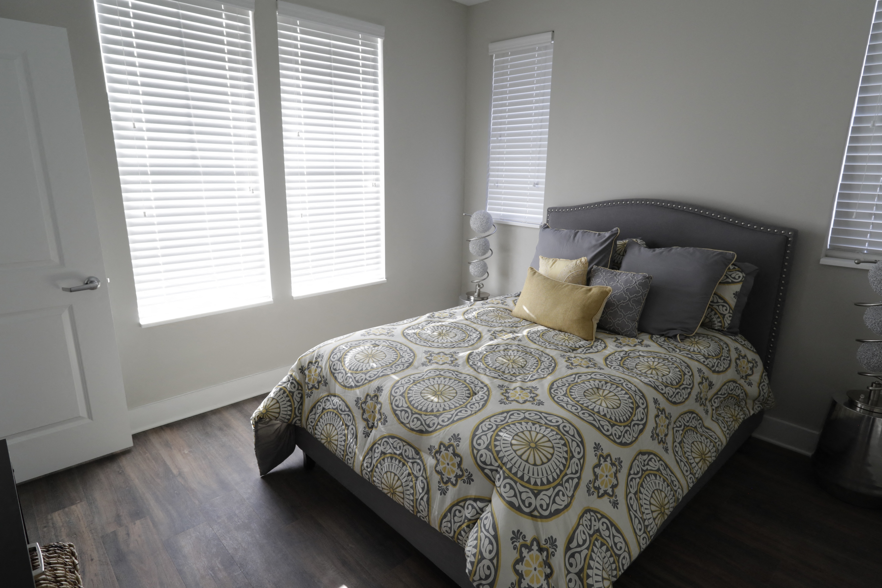 a bedroom with a bed and two windows