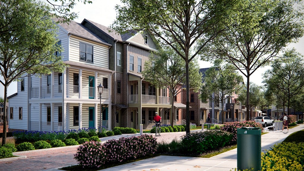 a row of town houses on a street with a person riding a bike