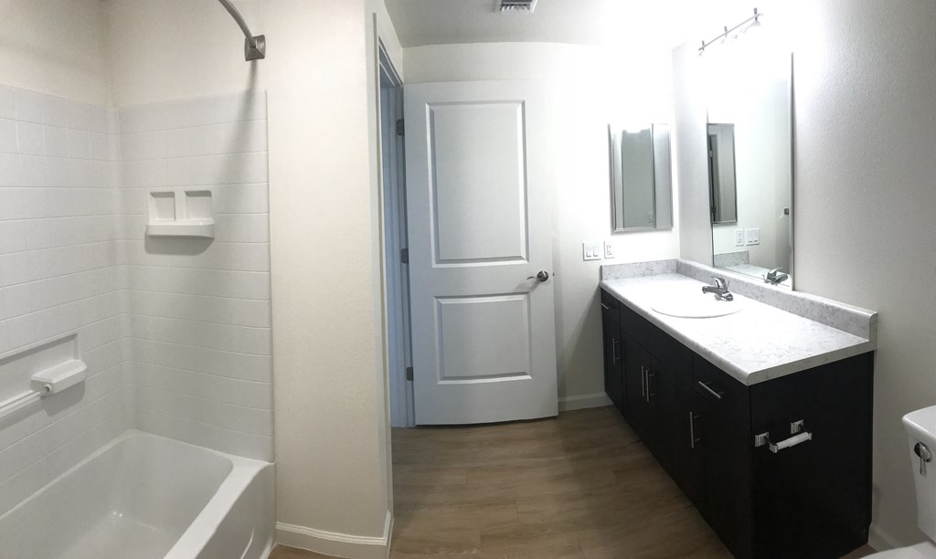 a bathroom with a sink and a bath tub and a door