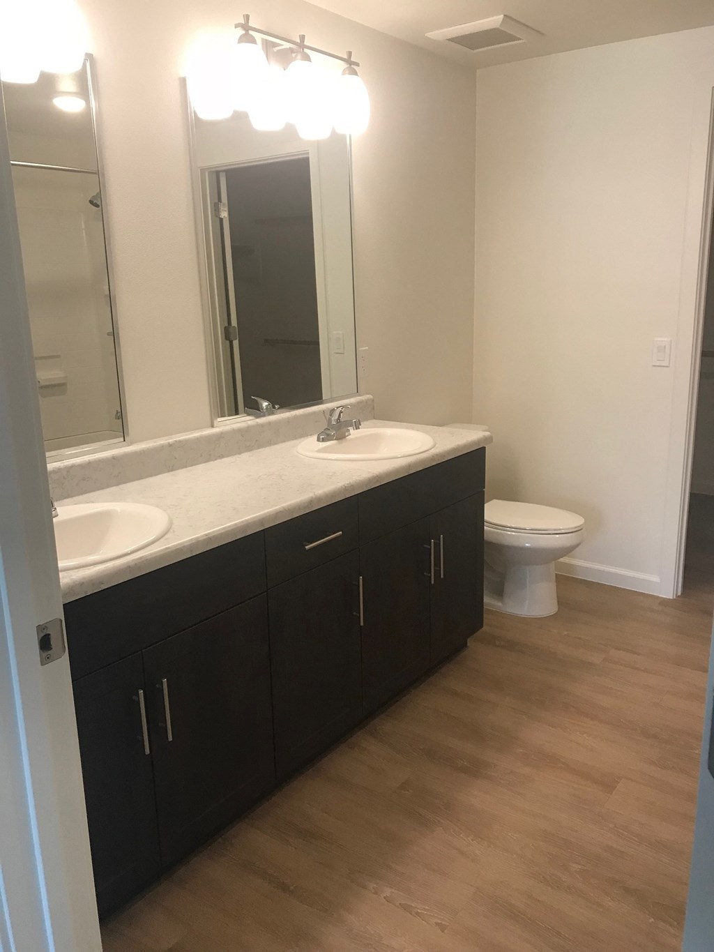 a bathroom with two sinks and a toilet and a mirror