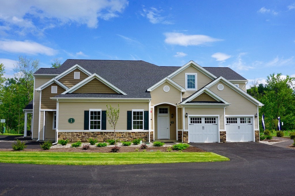 a house with two garage doors and a lawn