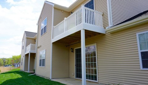 the back of a house with a porch and a balcony