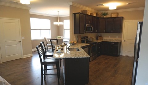 A kitchen with a table and chairs in front of it.