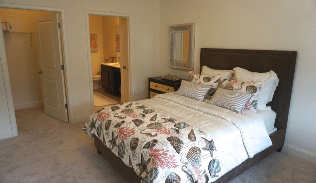 a bedroom with a bed and a bathroom with a sink