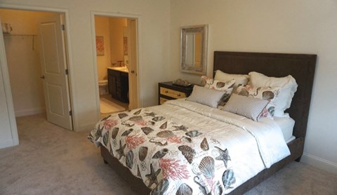 a bedroom with a bed and a bathroom with a sink