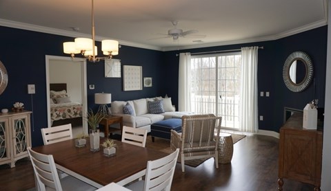 A dining room with a wooden table and white chairs.