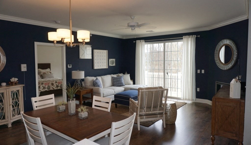 a dining room and living room with blue walls and white furniture