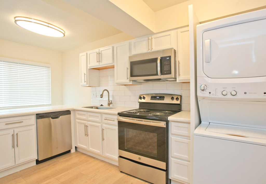 a kitchen with white cabinets and stainless steel appliances