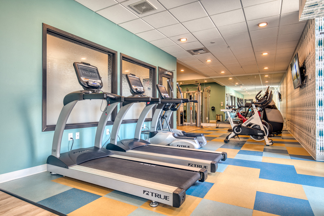 a gym with treadmills and other exercise equipment in a building with blue walls