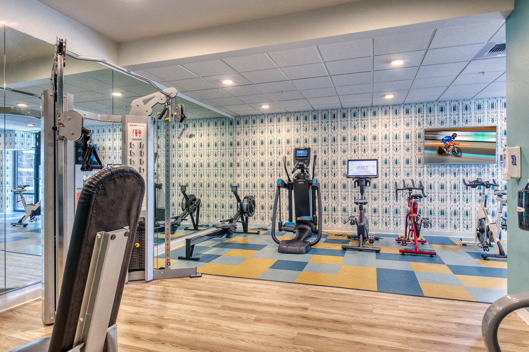a gym with weights and other exercise equipment on a blue and yellow floor