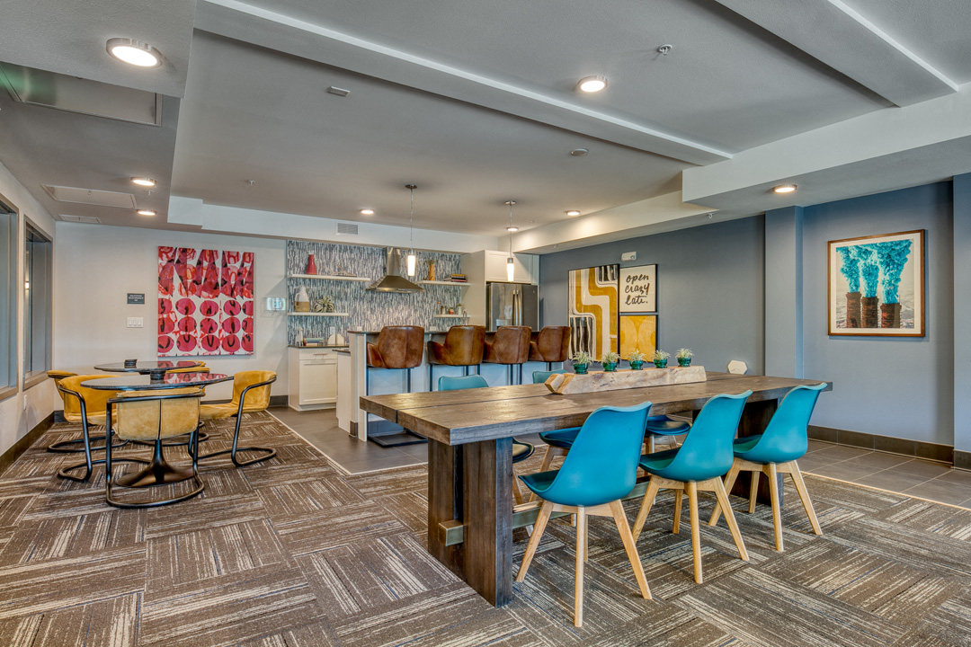 a dining room with a long table and chairs and a kitchen