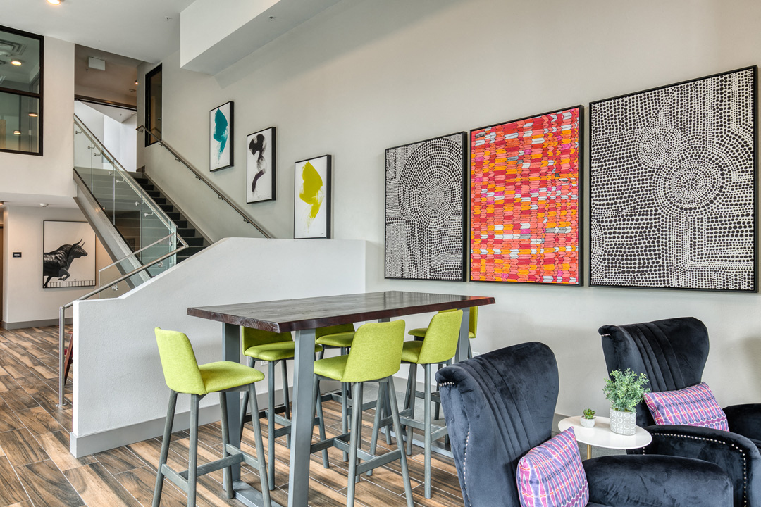 a dining area with a table and four chairs and a staircase