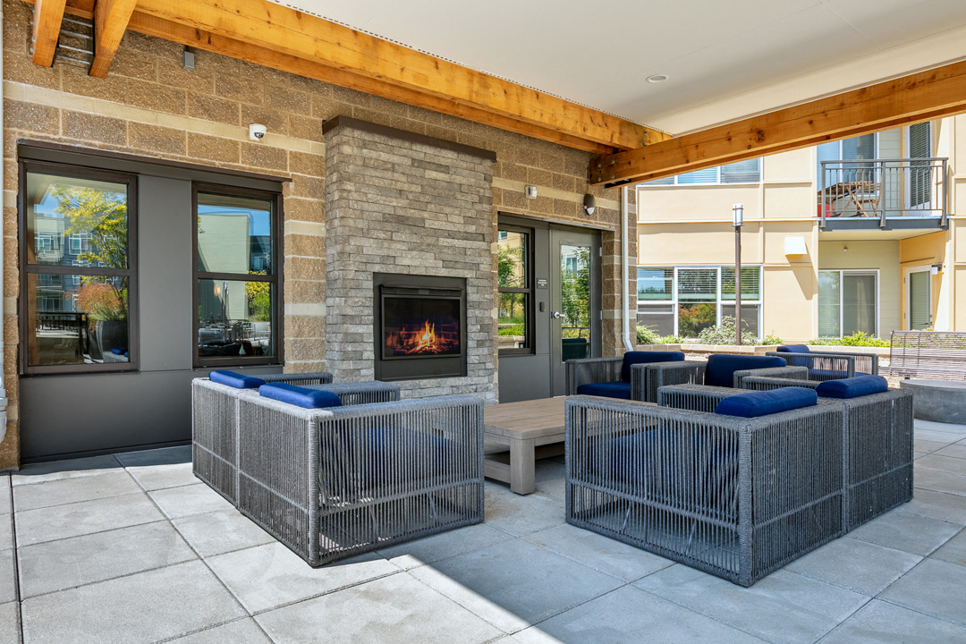a patio with couches and a fireplace