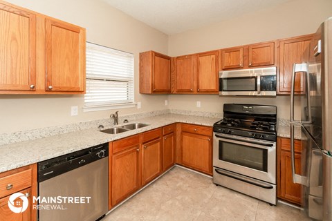 a kitchen with wooden cabinets and stainless steel appliances