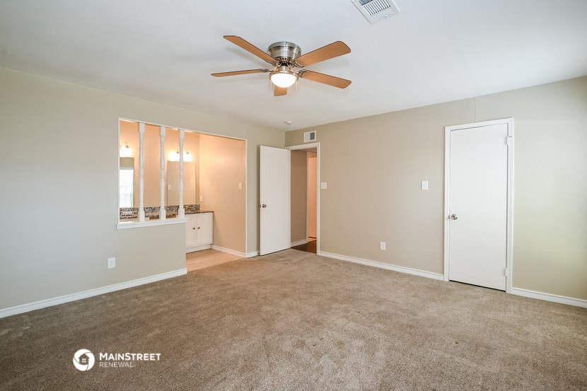 a living room with carpet and a ceiling fan
