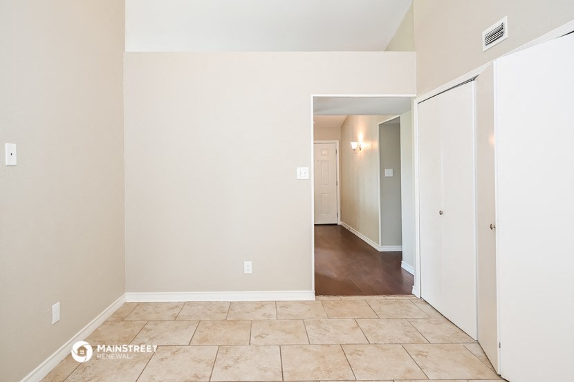 the living room and hallway of an empty house