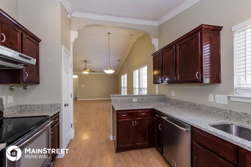 an empty kitchen with wooden cabinets and granite counter tops