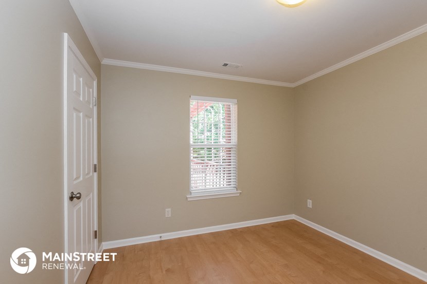 a bedroom with a white door and a window