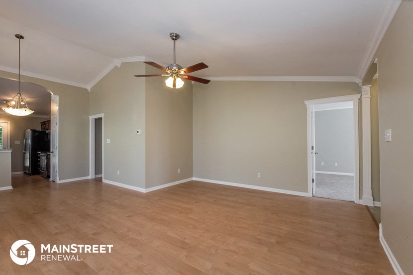 a living room with a ceiling fan and a wood floor