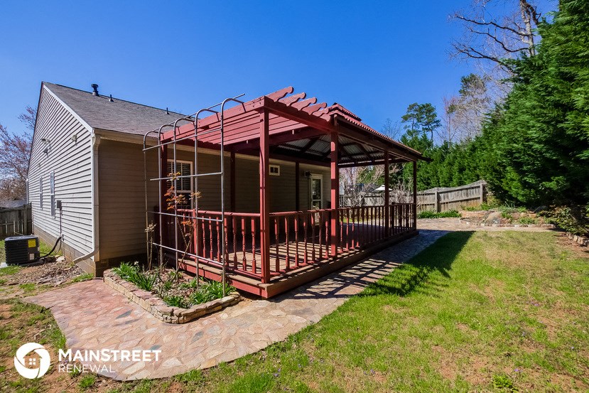 a house with a porch with a red metal roof