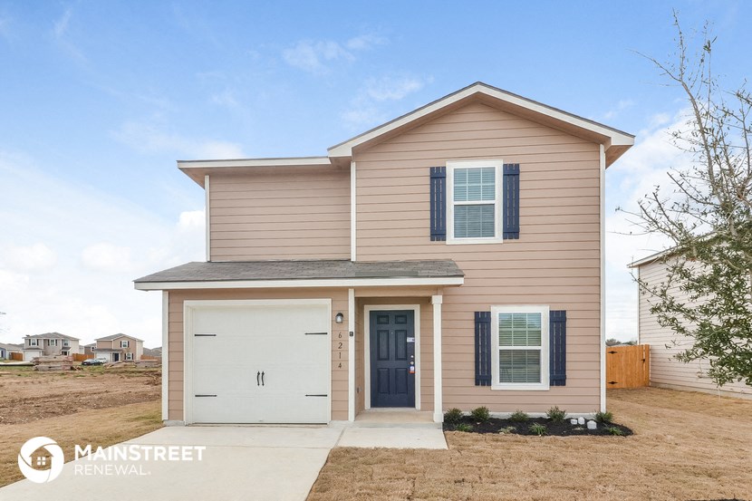 a beige home with a white garage door and a brown house