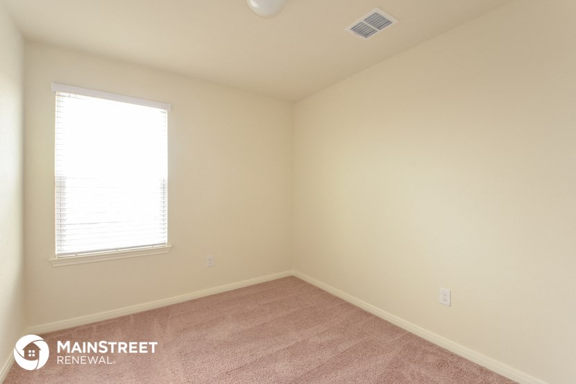 a bedroom with a carpeted floor and a window