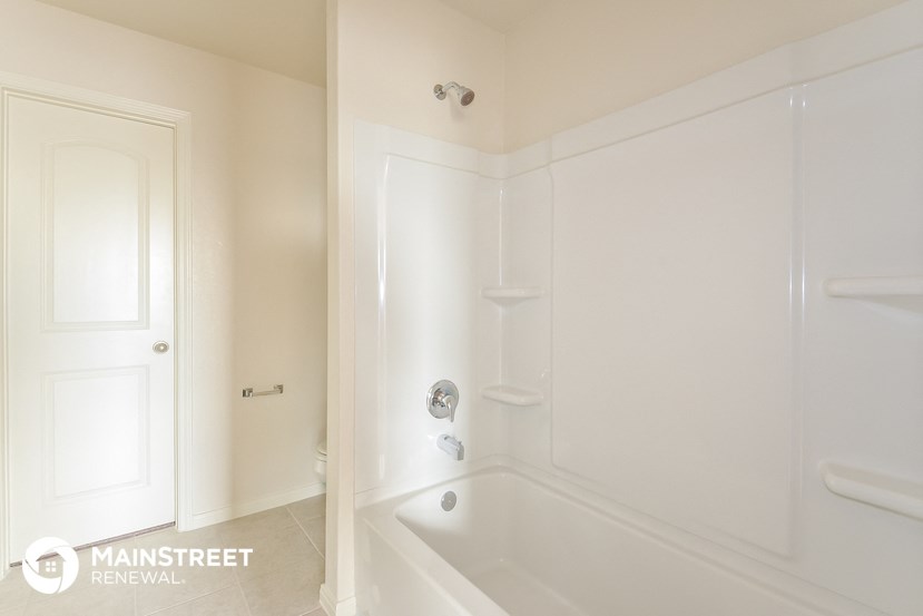 a bathroom with a tub and a shower and a door