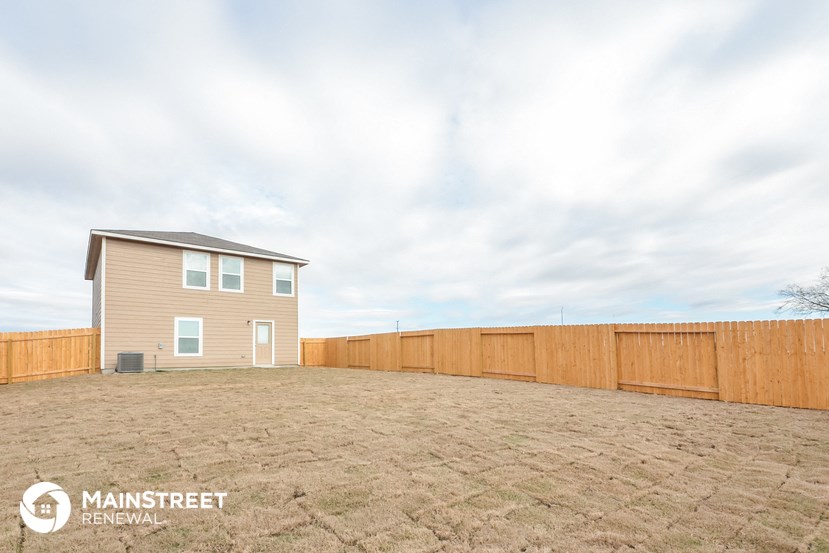 a backyard with a wooden fence and a house